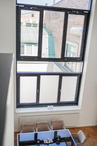 ventana grande en una habitación con mesa y sillas en The Grand Penthouse, en Viena