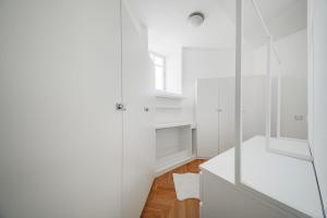 Baño blanco con armarios blancos y espejo en The Grand Penthouse, en Viena 56 fotos más