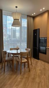 a kitchen and dining room with a table and chairs at Дизайнерская квартира рядом с Хан Шатыром in Astana