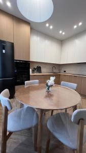 a table with chairs and a vase of flowers on it at Дизайнерская квартира рядом с Хан Шатыром in Astana +2 photos