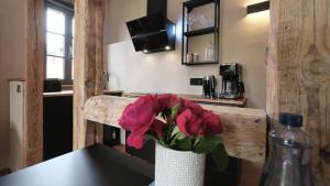 托尔高Altstadt Apartment in Torgau mit Balkon und Kunstgarten的花瓶,花朵粉红色,坐在桌子上 更多15张照片