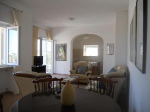 un soggiorno con tavolo e sedie di Appartamenti La Balestra a Ischia