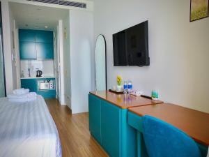 フーコックにあるAura Aparmentの青いキャビネット付きのキッチン、ベッド1台が備わる客室です。