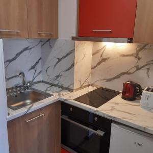 a kitchen with marble counter tops and a sink at ТЕС Боровец Гарденс in Borovets