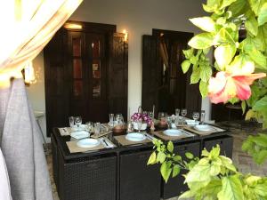 einen Esstisch mit Tellern und Gläsern darauf in der Unterkunft Casa Cortijo in La Luisiana