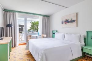 a bedroom with a large white bed and a window at IFA Schöneck Hotel & Ferienpark in Schöneck +79 photos