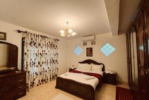 a bedroom with a bed and a chandelier at Villa Monza in Kandy