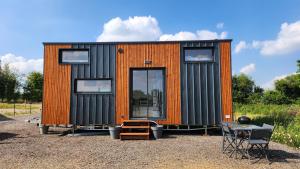 a tiny house sitting on top of a gravel lot at Tiny house proximité de Bernay in Grand-Camp
