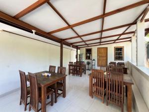 a dining room with a wooden table and chairs at Bara Cabana Hotel in Bira