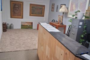 a room with a wooden counter with a desk and a table at Coratel Inn and Suites By Jasper Anthony in Anthony