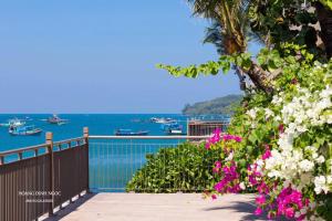フーコックにあるAura Aparmentの花の咲くバルコニーから海の景色を望めます。