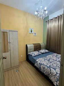 a bedroom with a bed and a chandelier at AYAAN Luxe Premium FIFA house with Free WiFi and Netflix in Tanah Rata