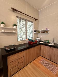 a kitchen with a black counter and a window at AYAAN Luxe Premium FIFA house with Free WiFi and Netflix in Tanah Rata +17 photos