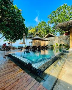 una piscina en un resort con mesas y sombrillas en Serendipity Mirissa, en Mirissa