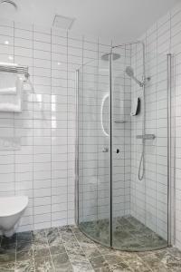a glass shower in a bathroom with a toilet at Stay Inn Apartments in Vasastan in Stockholm +17 photos