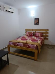 a bedroom with a wooden bed in a room at Khushi Waves in Arpora