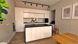 una cocina con armarios blancos y un jarrón de flores en Sonnenplatz mit Parkplatz - Zentral und Elegant, en Bad Rothenfelde
