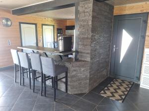 a kitchen with a bar with a stone wall at Villa de rêve en pleine nature in Apremont-la-Forêt