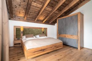 a bedroom with a large bed and a wooden ceiling at Das Grabnergut in Bad Hofgastein