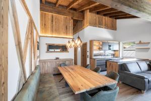 a kitchen and living room with a wooden table and chairs at Das Grabnergut in Bad Hofgastein