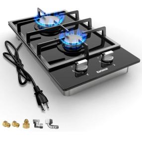 a gas stove with a pair of tongs next to it at Private double Delight Couple Room in Abu Dhabi