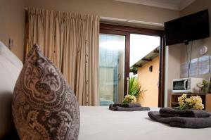 a bedroom with a bed with two pillows on it at a Vue Guesthouse in Somerset West