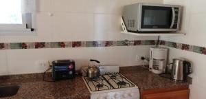 a kitchen with a stove and a microwave at Rincón Bonito in El Hoyo