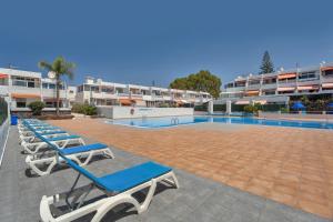 a row of lounge chairs next to a swimming pool at Hand Made Suite Costa del Silencio in Costa Del Silencio