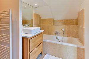 a bathroom with a sink and a bath tub at Maison normande deauville in Bonneville-sur-Touques +12 photos