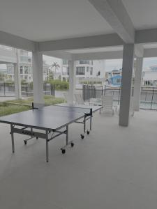 two ping pong tables in a large room with chairs at 141 Brand New Luxury 6BR 6BA Build with Heated Pool! home in Fort Myers Beach