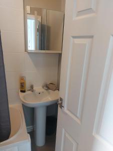 ein Badezimmer mit Waschbecken und Spiegel in der Unterkunft Maritimum House in Westoe