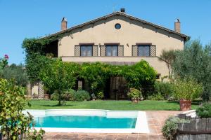 a house with a swimming pool in front of it at Casale Farnia in Montecastrilli