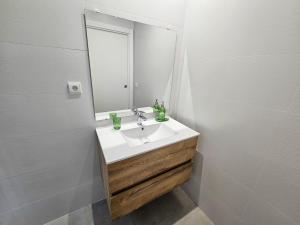a bathroom with a sink and a mirror at Apartamentos Zaragoza Reconquista 3000 in Zaragoza +39 photos