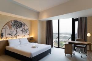 a hotel room with a bed and a desk at Cove Carstensz BSD in Kramat