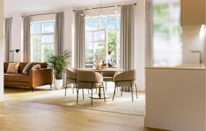 a living room with a table with chairs and a woman sitting at it at Apartment Heiligenstadt in Bad Frankenhausen