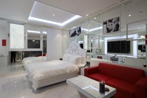 a bedroom with a bed and a couch and a tv at Gimhae Hotel Hiem in Samgong
