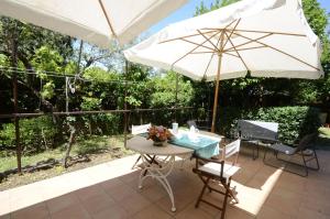 a patio with a table and an umbrella at Casa Di Silvana in Morena