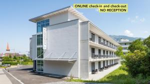 an office building with a large window on the side at Anstatthotel Goldau - self-check-in in Goldau