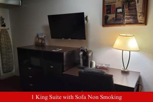 a office with a desk with a tv and a lamp at Coratel Inn & Suites by Jasper Hutchinson in Hutchinson