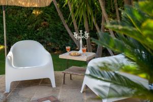 una mesa con una silla y dos copas de vino en Villa Letto D'Alloro - Royal Dream, en Conversano