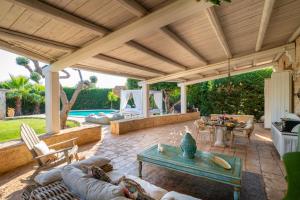 an outdoor patio with a wooden pergola at Villa Letto D'Alloro - Royal Dream in Conversano