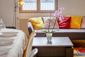 - un salon avec un canapé et des oreillers colorés dans l'établissement Agapanthes jolie maison de ville à Rouen avec extérieur terrasse, à Rouen
