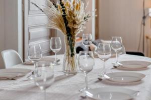 une table avec des verres à vin et un vase avec des fleurs dans l'établissement Agapanthes jolie maison de ville à Rouen avec extérieur terrasse, à Rouen 39 autres photos