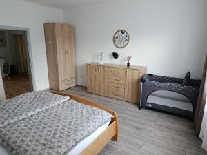 a bedroom with a bed and a wooden dresser at Apartman Silvia in Breitenau