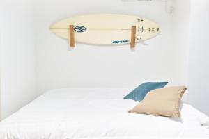 a surfboard hanging on a wall above a bed at Z LAND Enoshima in Fujisawa