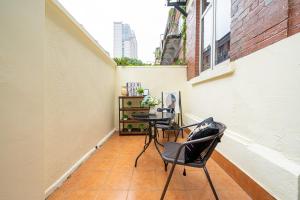 a small balcony with a table and chairs on a building at Shanghai Hills & Well-time MCM Family B&B with Terrace Near Line2 Jing'an Temple in Shanghai