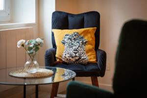 a blue chair with a pillow on it with a table at Ceylan bel F2 à Rouen in Rouen