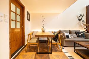 a living room with a table and a couch at Shanghai Hills & Well-time MCM Family B&B with Terrace Near Line2 Jing'an Temple in Shanghai