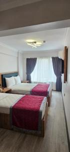 una camera d'albergo con due letti e una finestra di Hatay Hotel a Istanbul