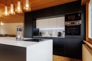 a kitchen with black cabinets and a white counter top at Luxe Davos Residence with Views Private Balcony in Davos